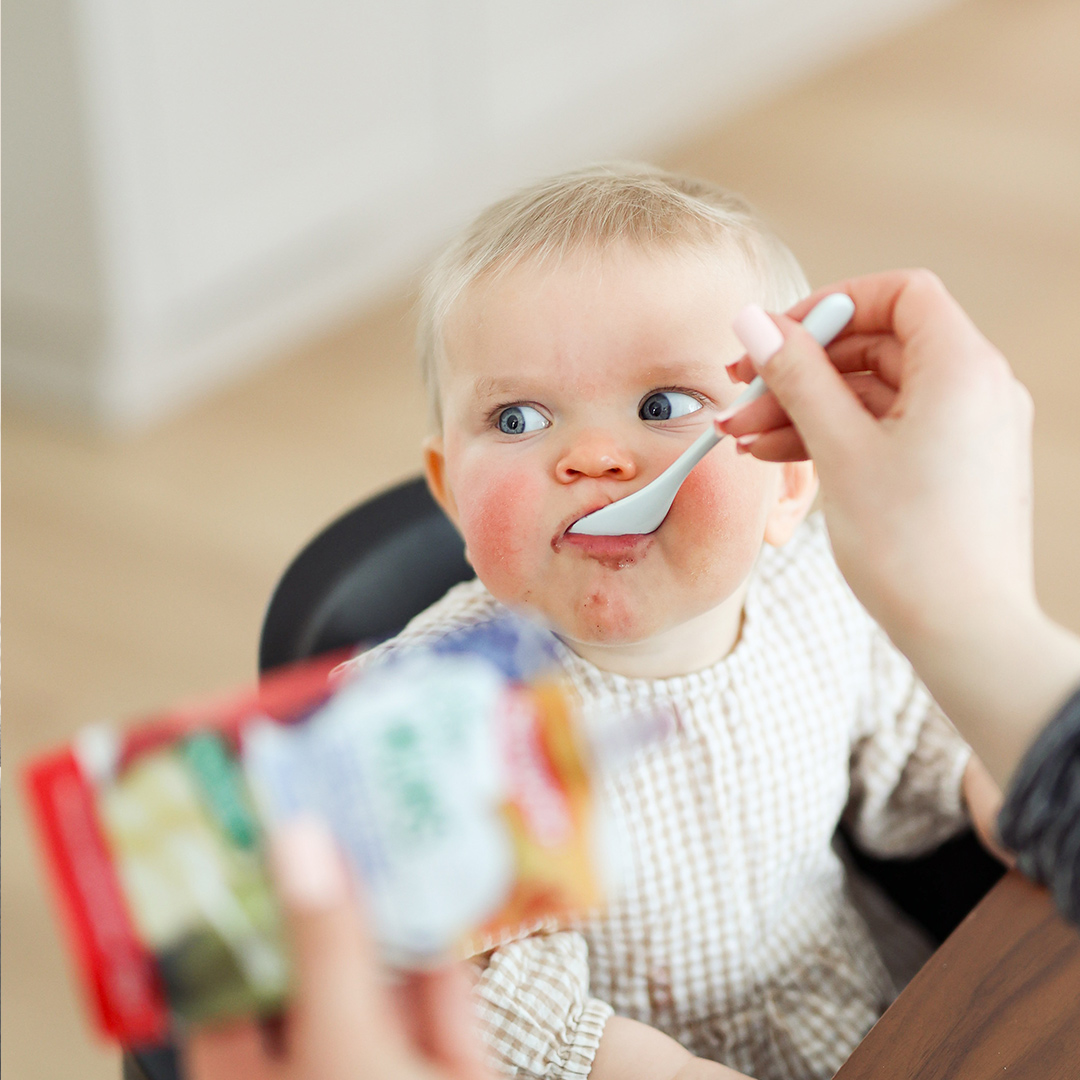 Baby being fed Semper pouch from spoon