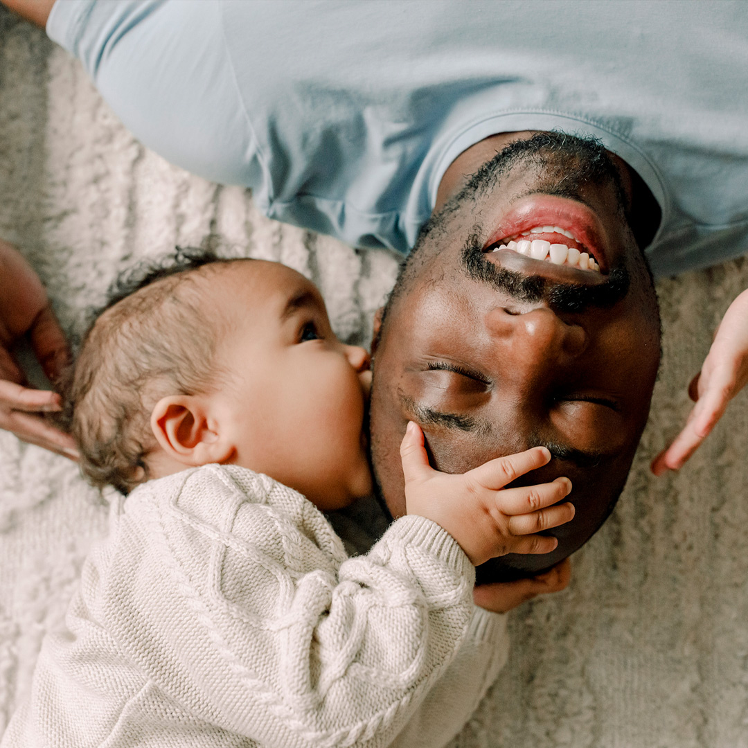 Baby trying to eat fathers head